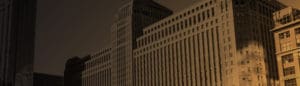 A banner image of a large city building in downtown Chicago with a gold and black gradient